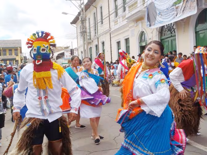 Aya Uma con máscara tejida y zamarro de piel danzando junto a mujeres de pollera